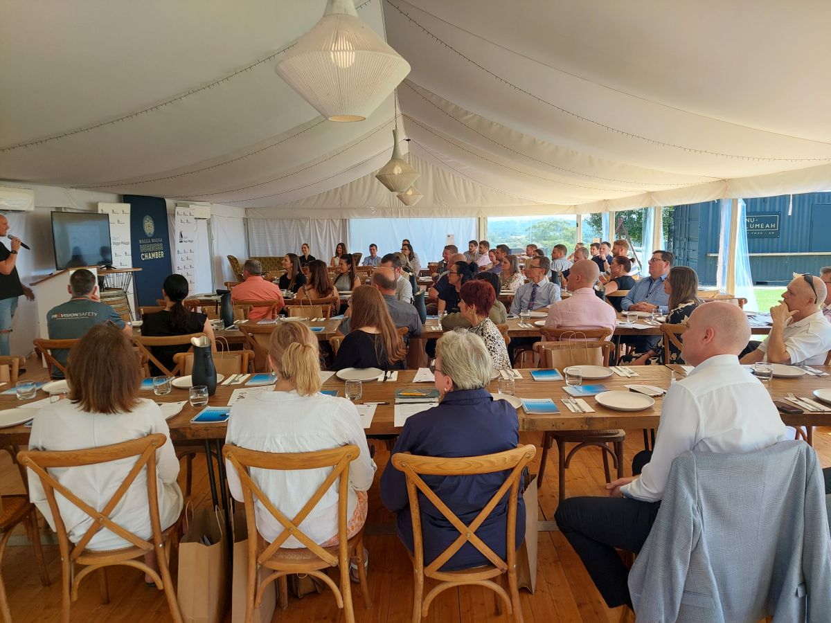 Group of people in a marquee listening to a speaker