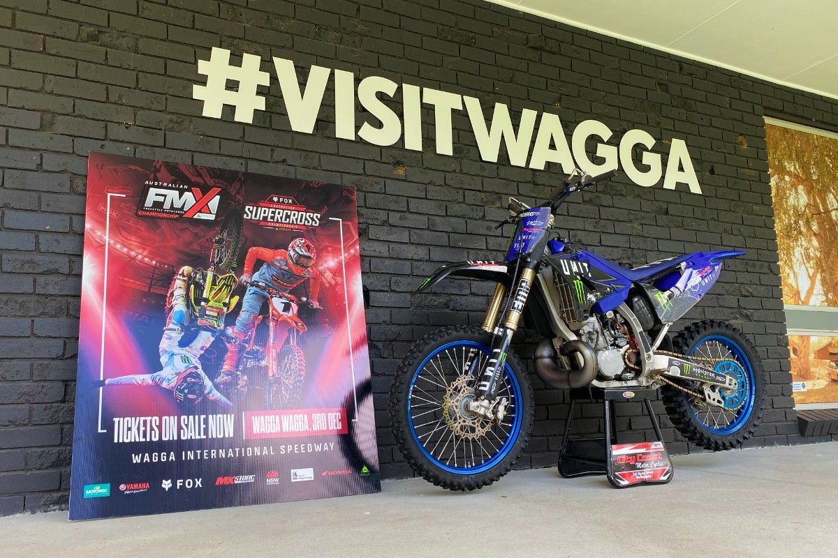 Promotional sign and motorbike leaning again Visitor Information Centre wall