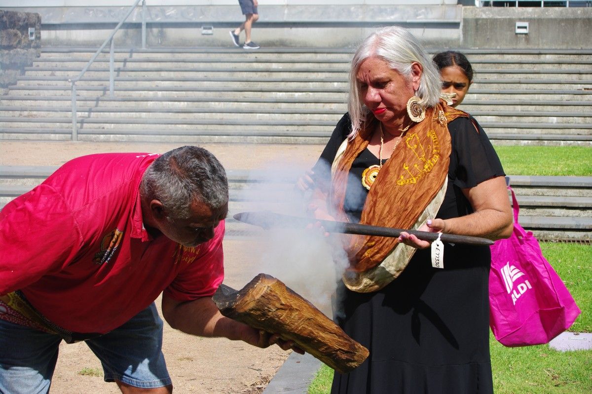 First Nations man and woman at smoking ceremony for Wiradyuri object