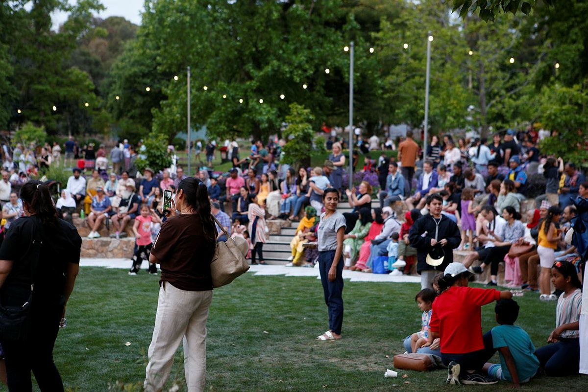 A crowd of people sitting in an amphitheater during a community event.  