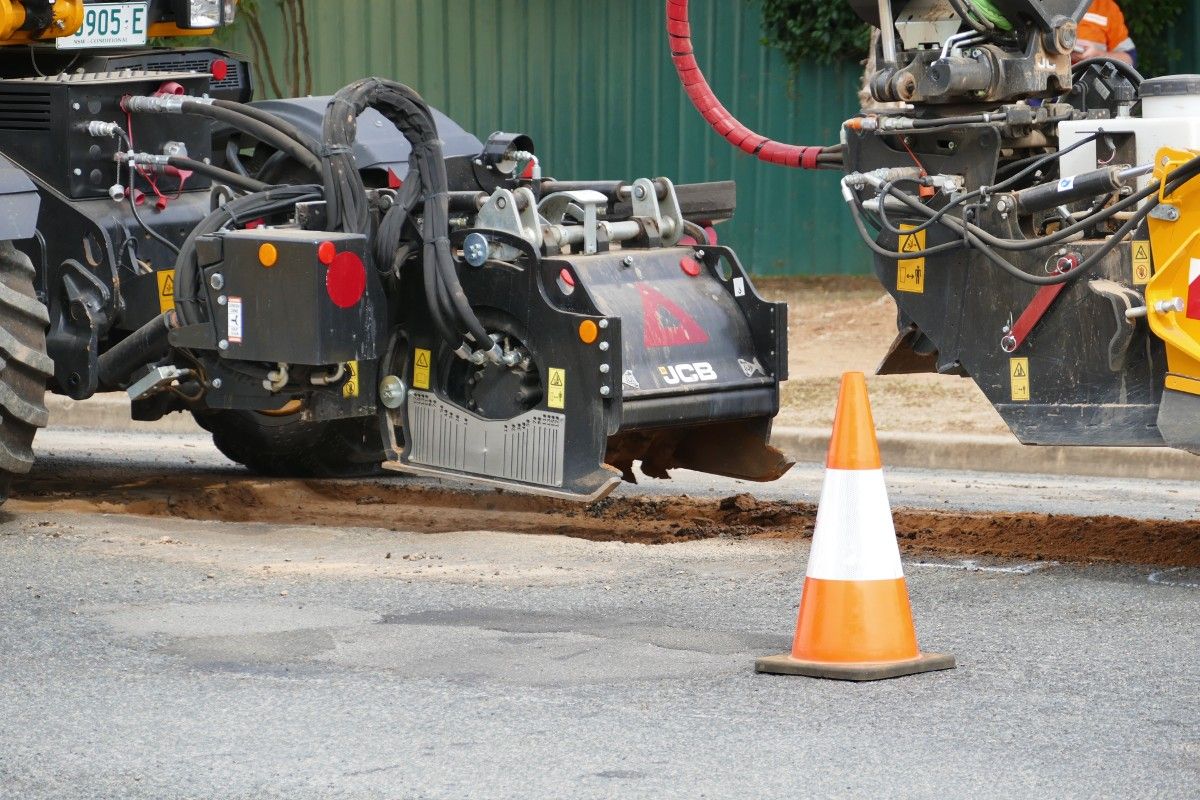 Close up of profiling attachment on a Pothole Pro machine during pothole repair on suburban road.