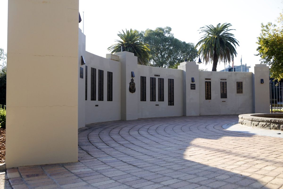 Rendered wall of a memorial with plaques bearing names of soldiers killed during World War Two.