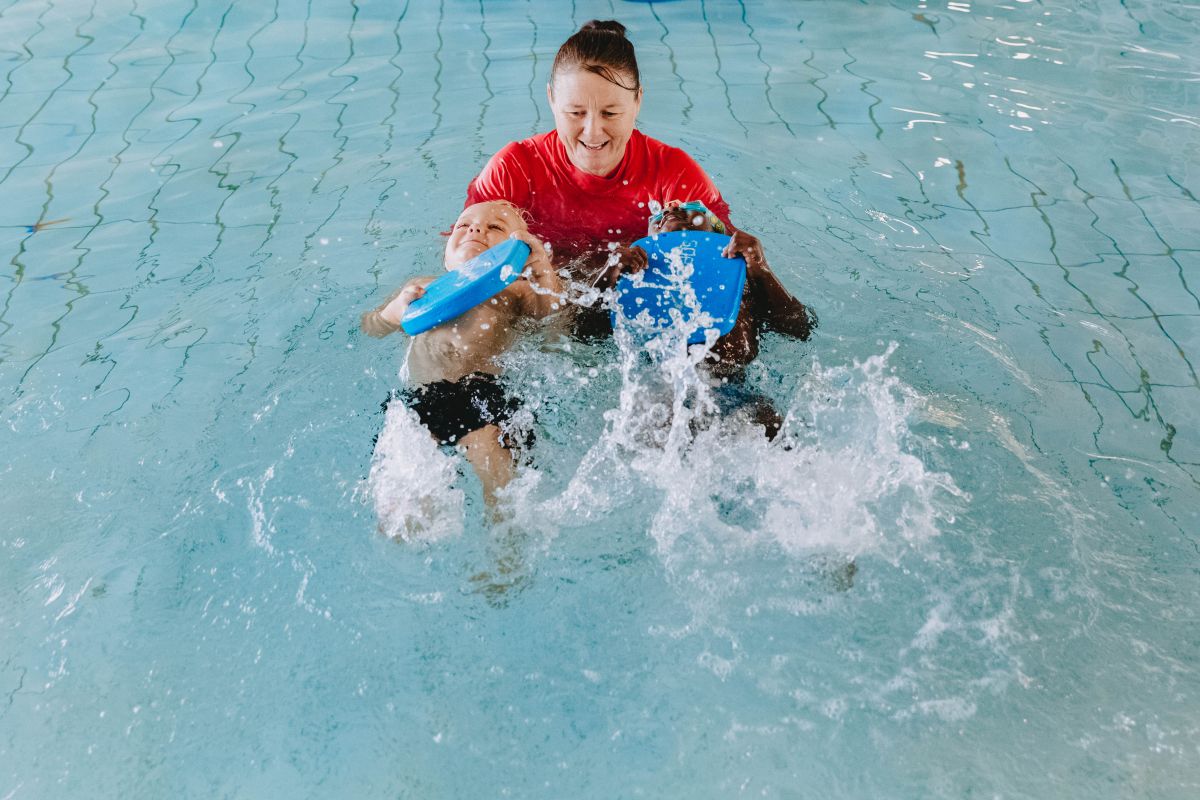 Swimming instructor coaches two young children