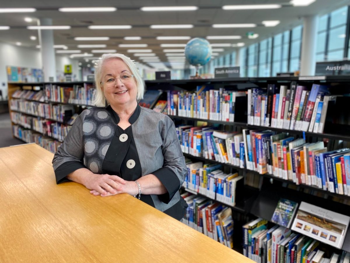 Woman standing in front of bookshelf