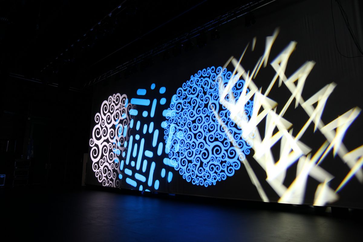 Four circular lights are projecting on the stage wall showing various patterns and colours.