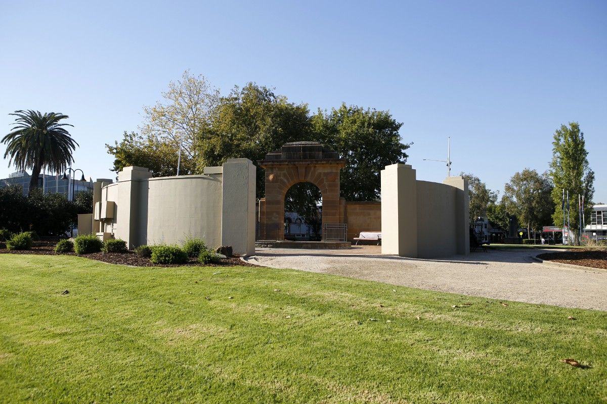 Wide view of the exterior of the Honour Roll walls, surrounding garden beds and grass lawn in the foreground.
