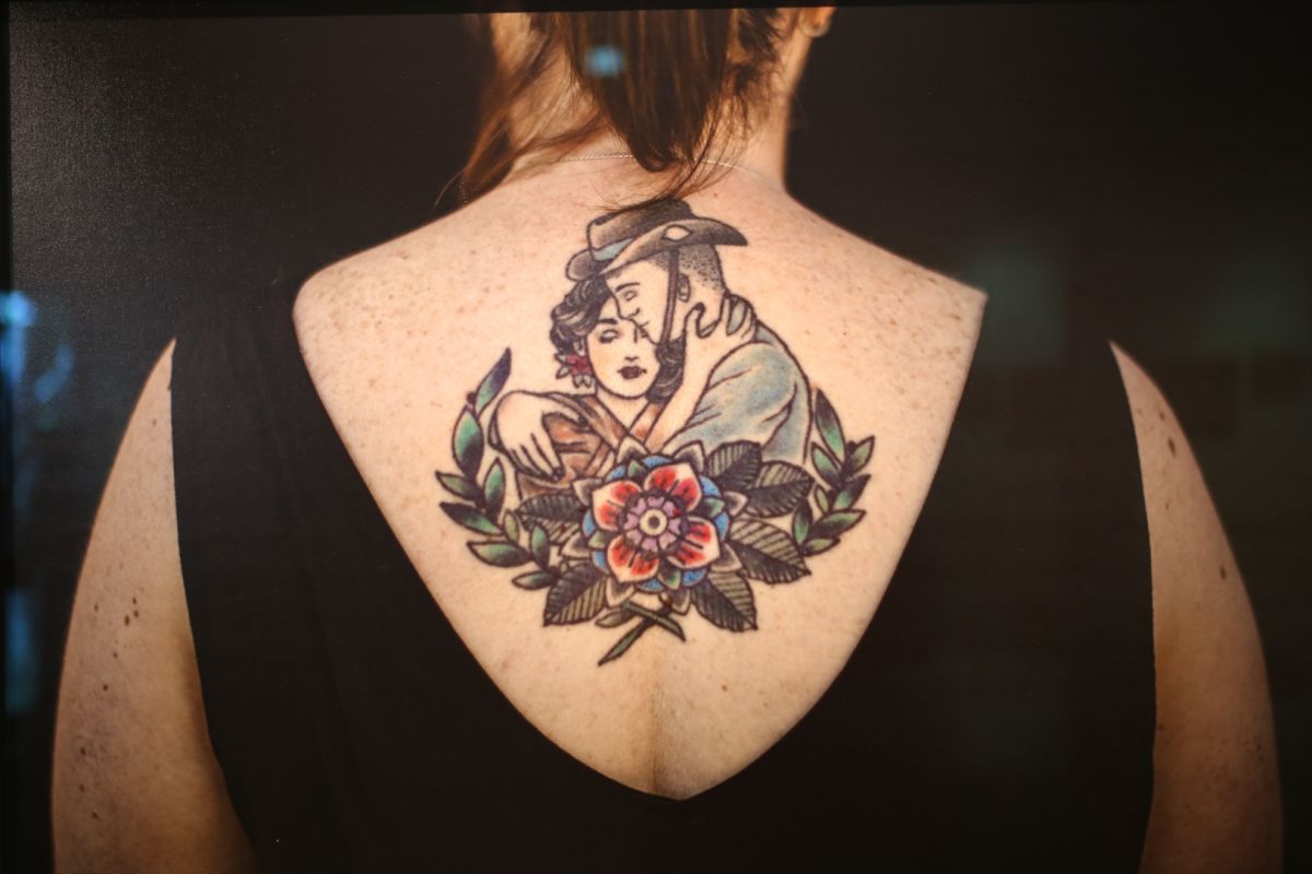 Tattoo of woman and soldier on woman's back