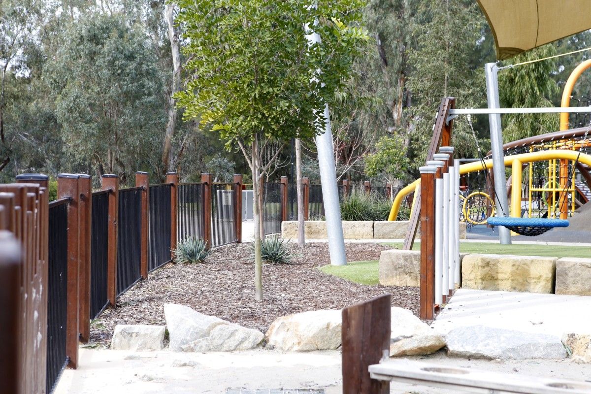 Wooden and metal railing fence on the outside of a playground