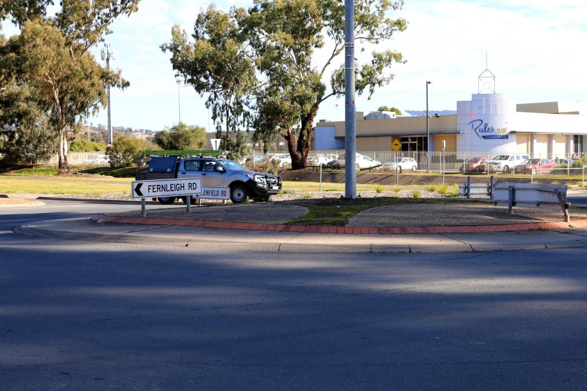 Roundabout with one car travelling around it