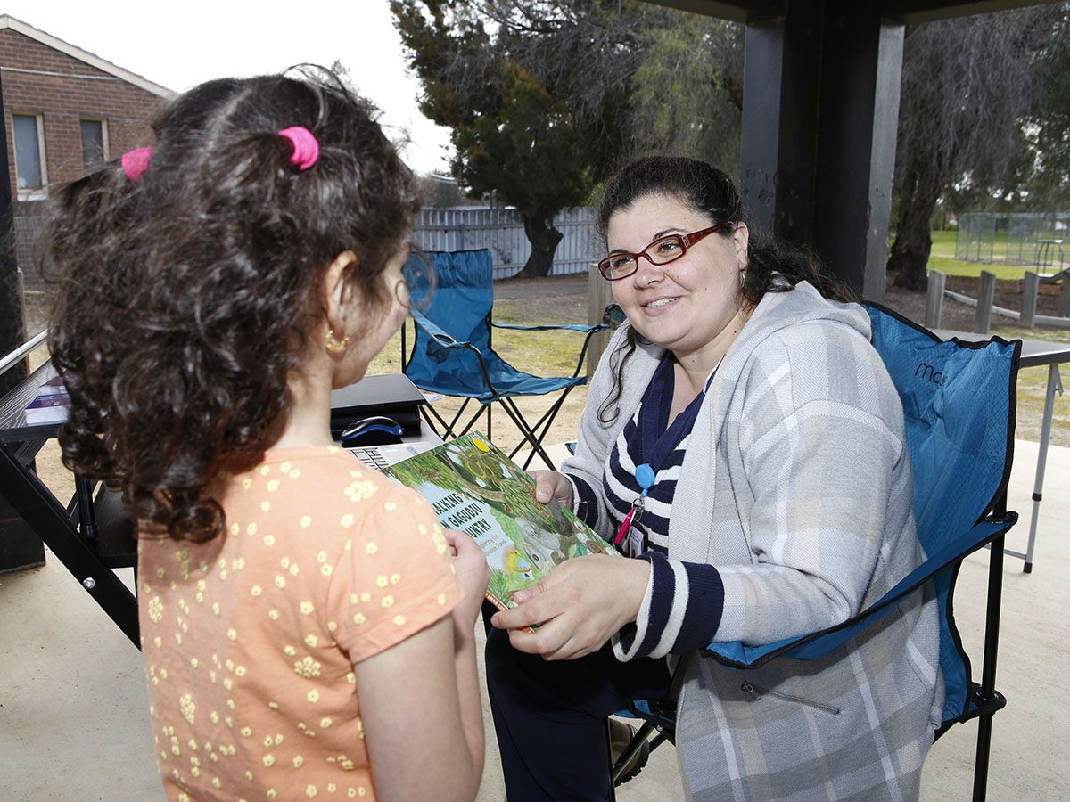 Mariya Sulaiman, 5, gets some technology tips from Agile Library Officer Rachael Downes during a visit by the new Agile Library van to the Tolland Glenfield Neighbourhood Centre