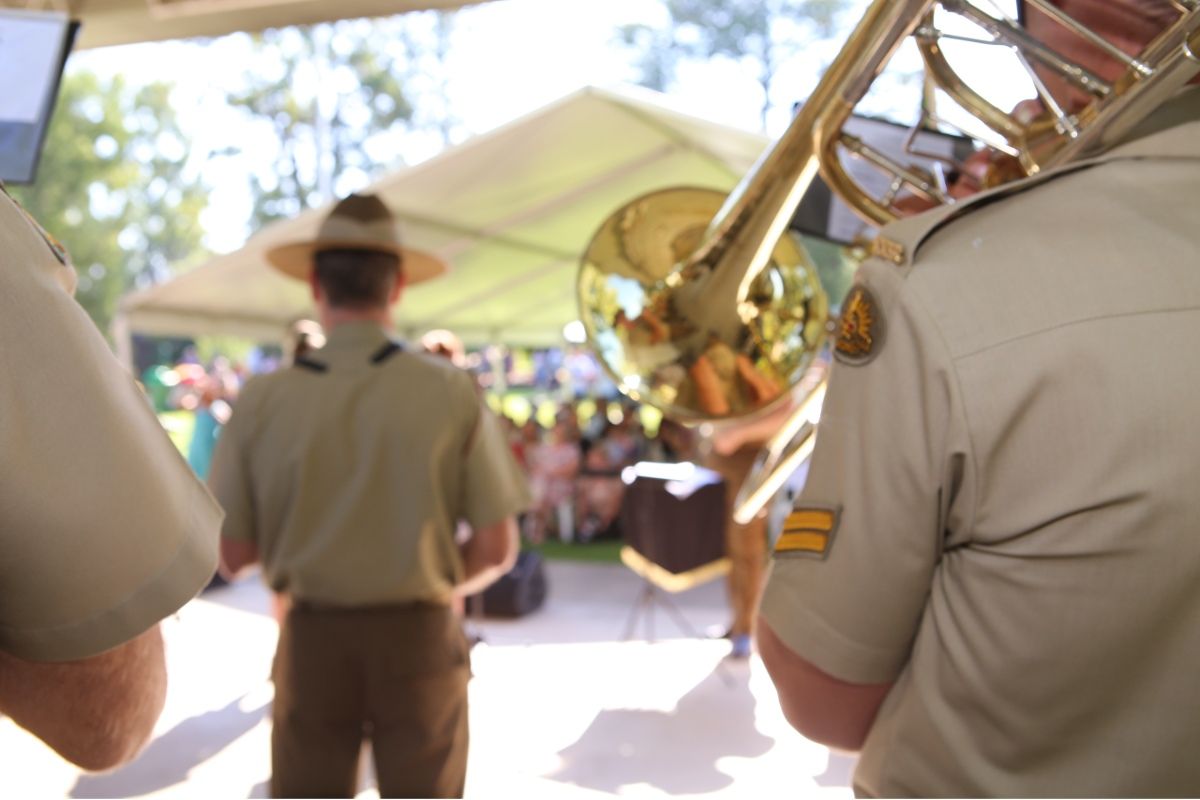 Back view of two Australian Army musicians playing their band instruments at Victory Memorial Gardens