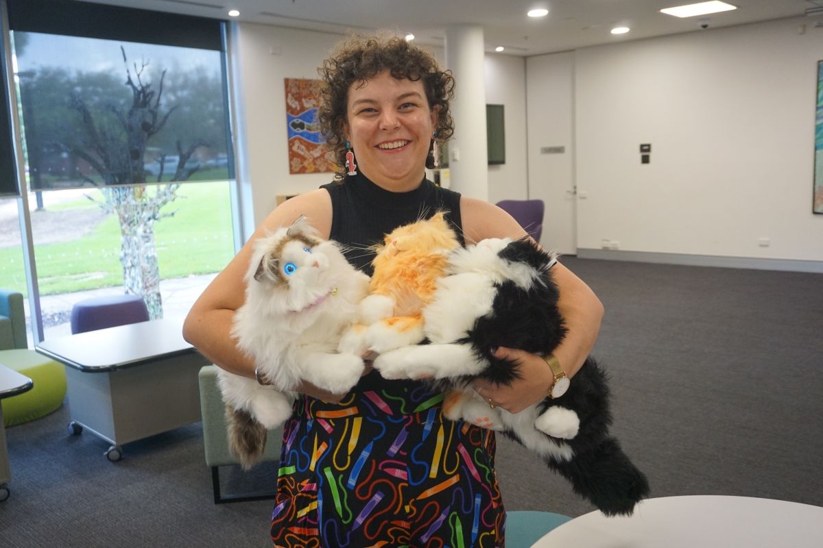 Library Programs Officer Beth Harrison with the Library’s five robotic cats. 