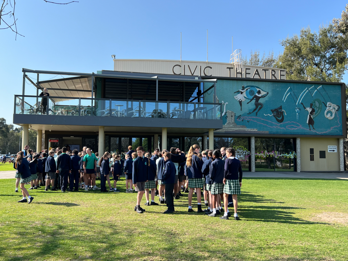 A large group of primary school students are gathered out the front of the Wagga Wagga Civic Theatre.