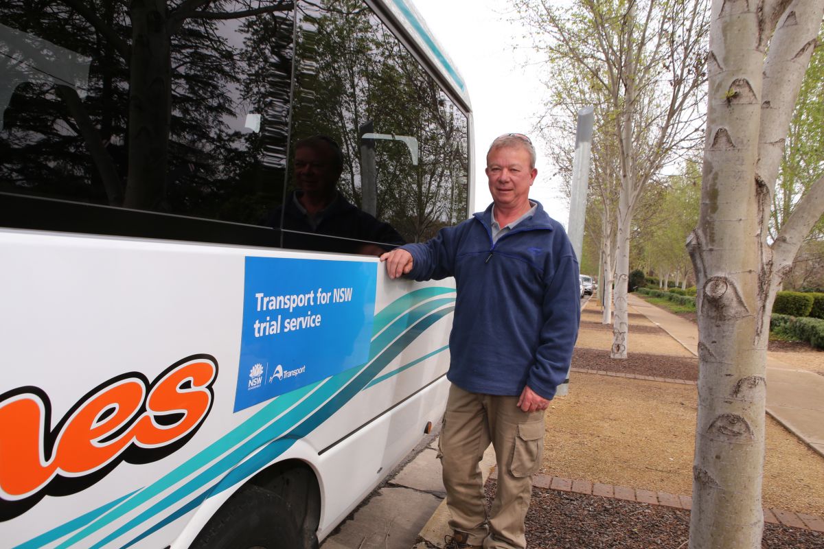 Man standing beside small bus