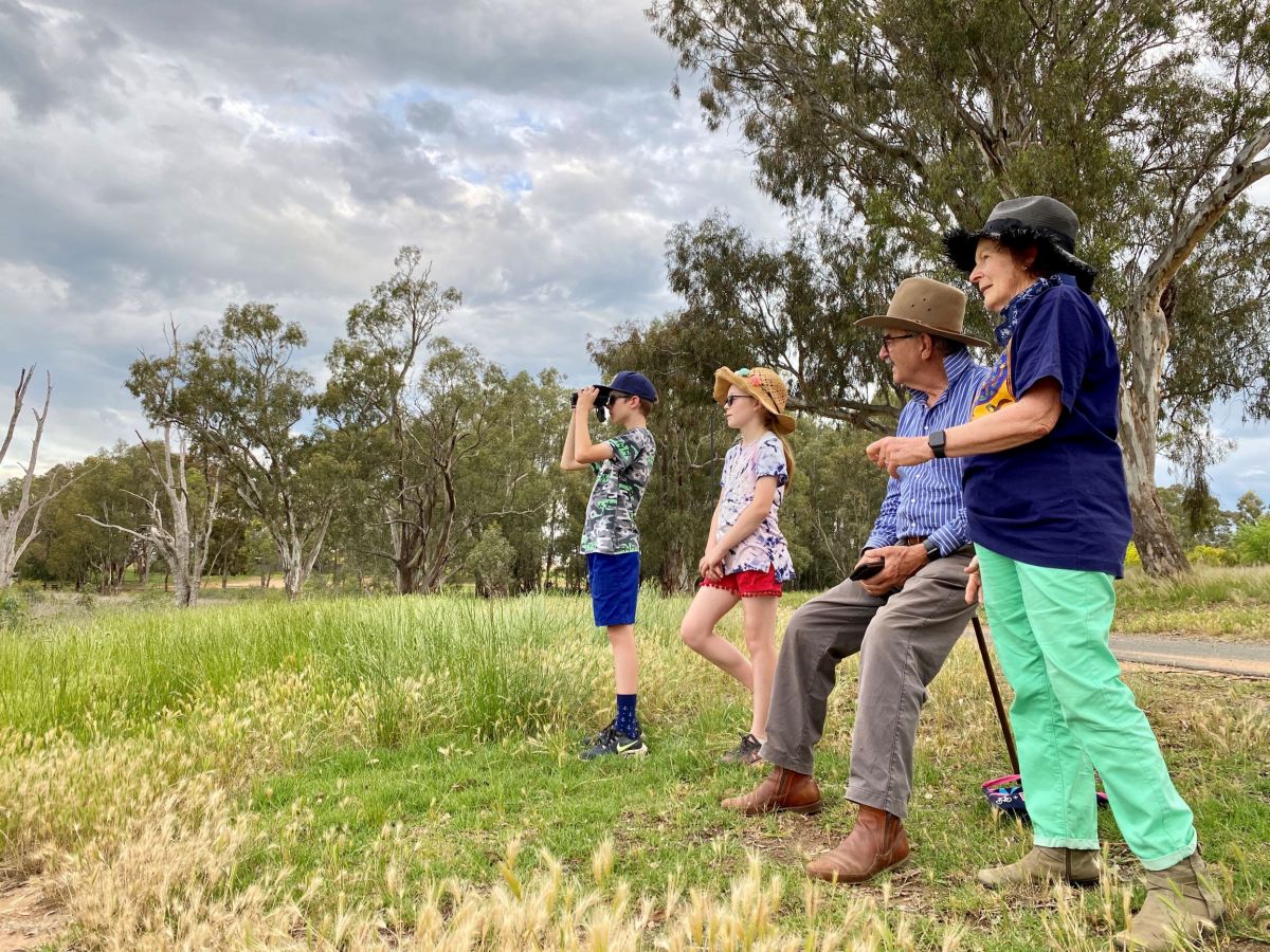 Two children and two adults standing in a park