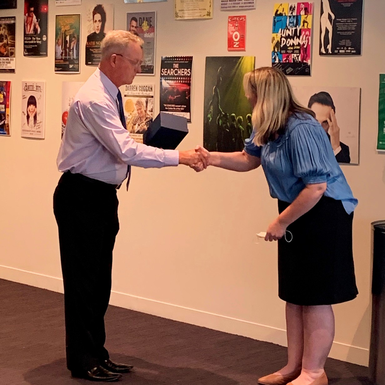 man presenting woman with trophy