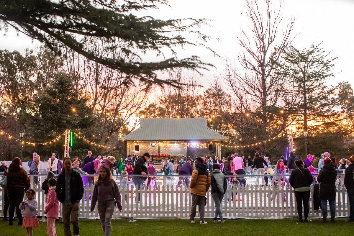 Pop up ice rink, skaters, people in Victory Memorial Gardens