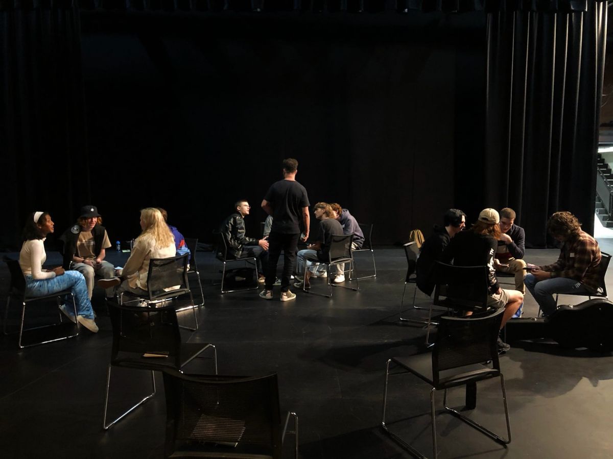 Three groups of budding young musicians sitting on stage with mentors