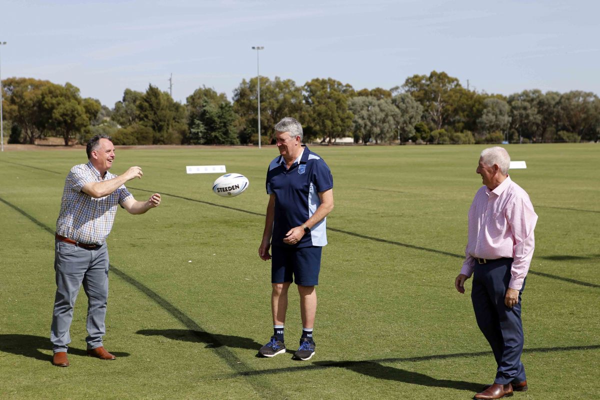 Three men on touch football field through ball to each other