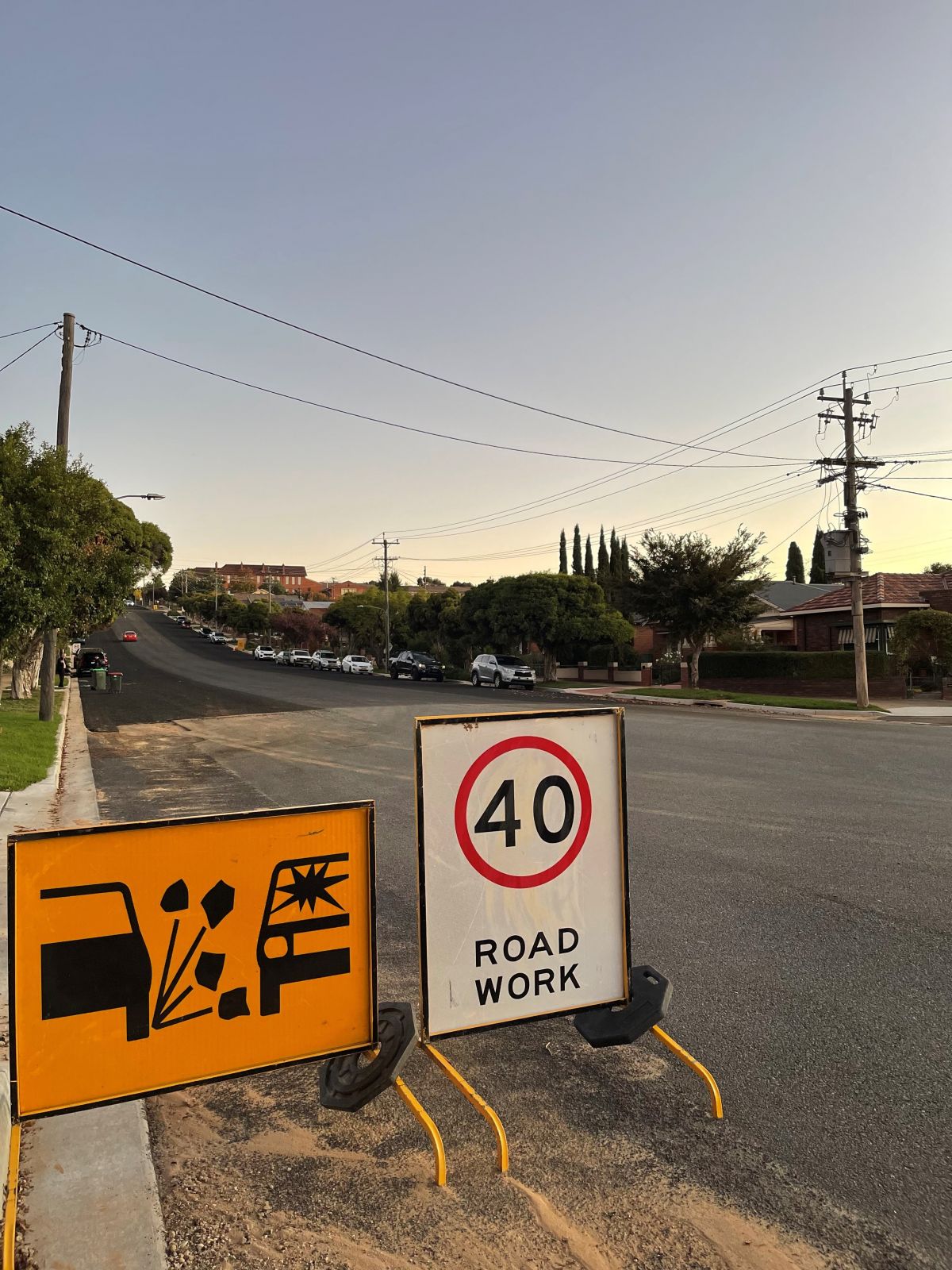 Fresh seal on road with 40kph sign in foreground