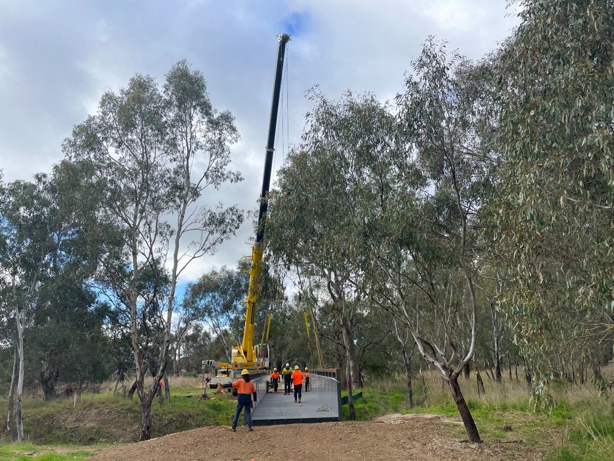 Workers fitting a steel bridge over Marshalls Creek on ATP path at Koorginal