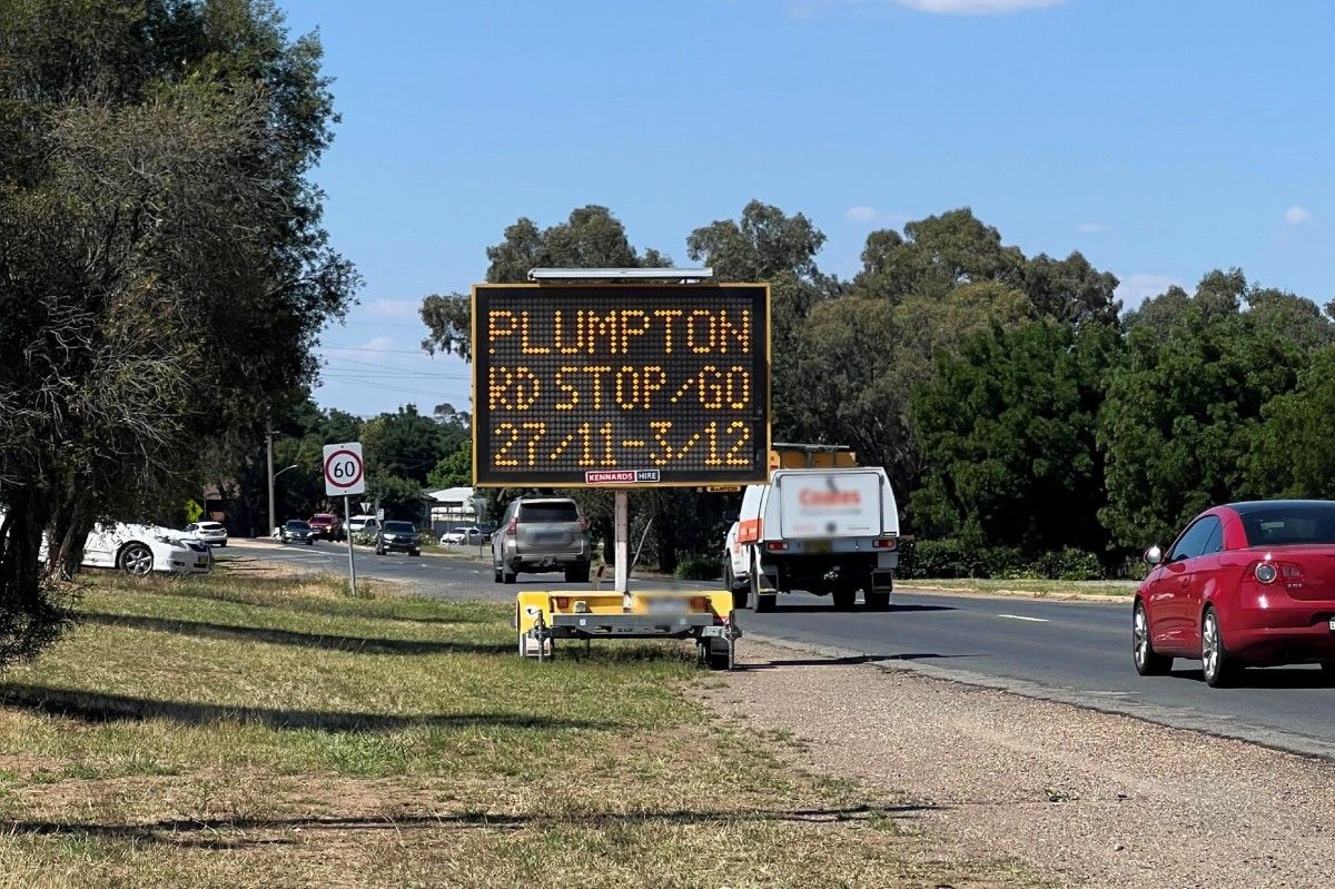 A VMS board located on the side of a busy road