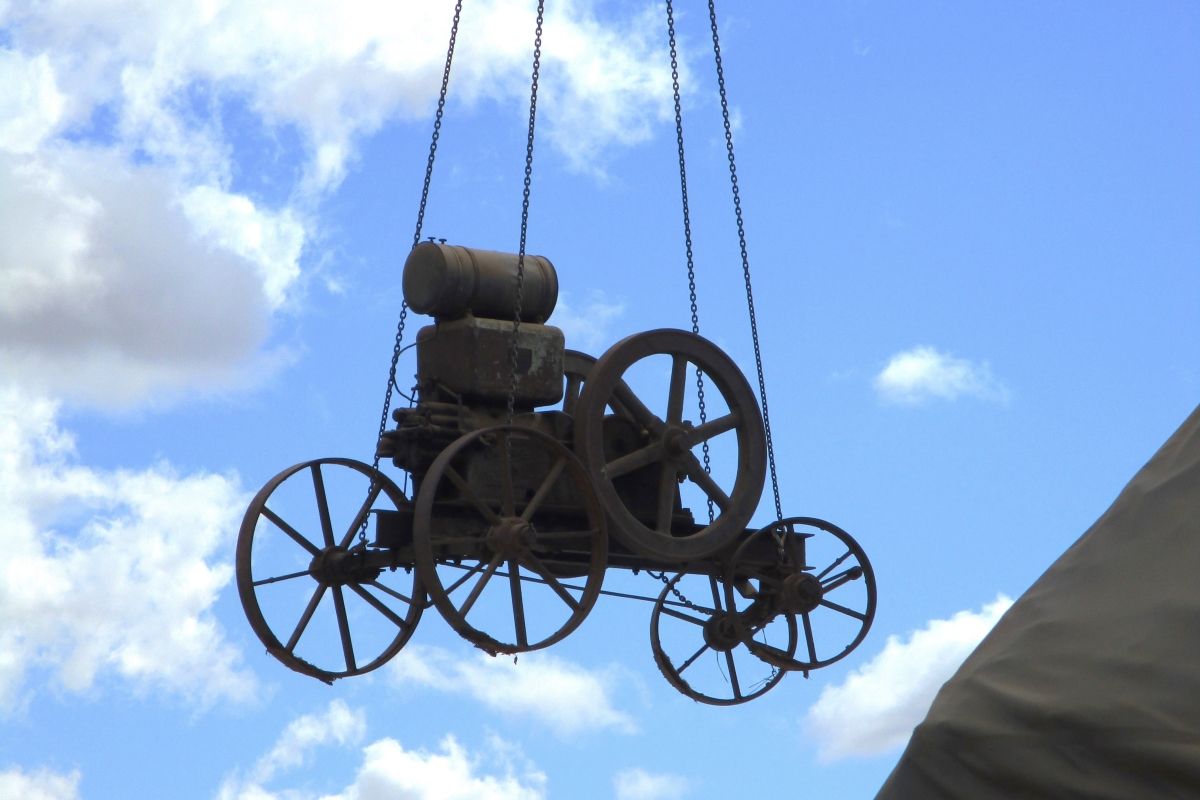 One of the older farm machines being craned into redeveloped Museum of the Riverina site.