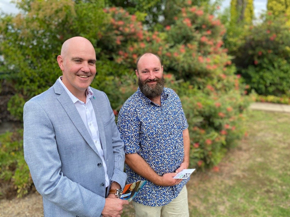 Two men standing in a garden setting