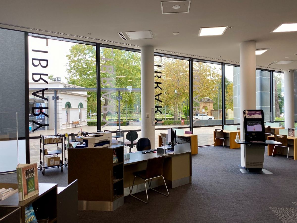 View from inside the library looking out the front windows towards a leafy park