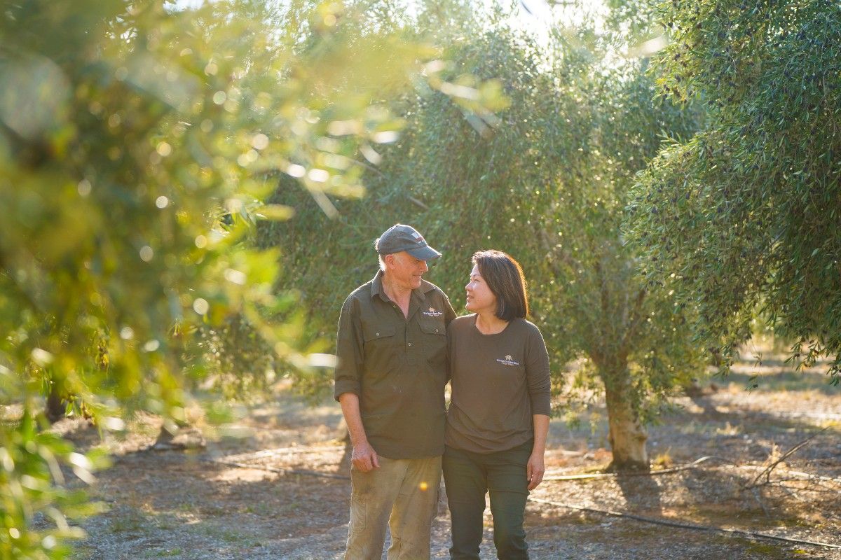 Man and woman walking through orchard