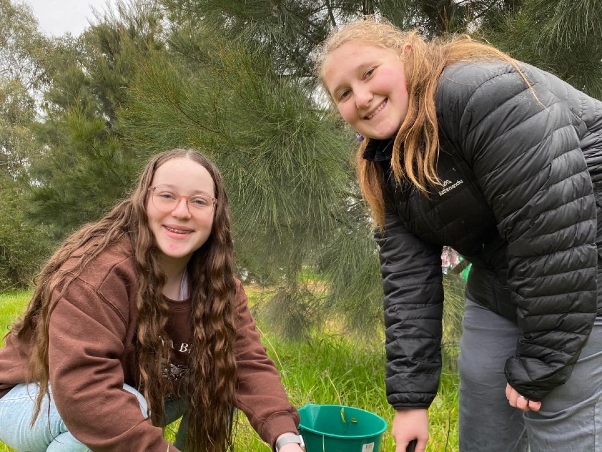 Two teenage girls smiling in a bushland setting