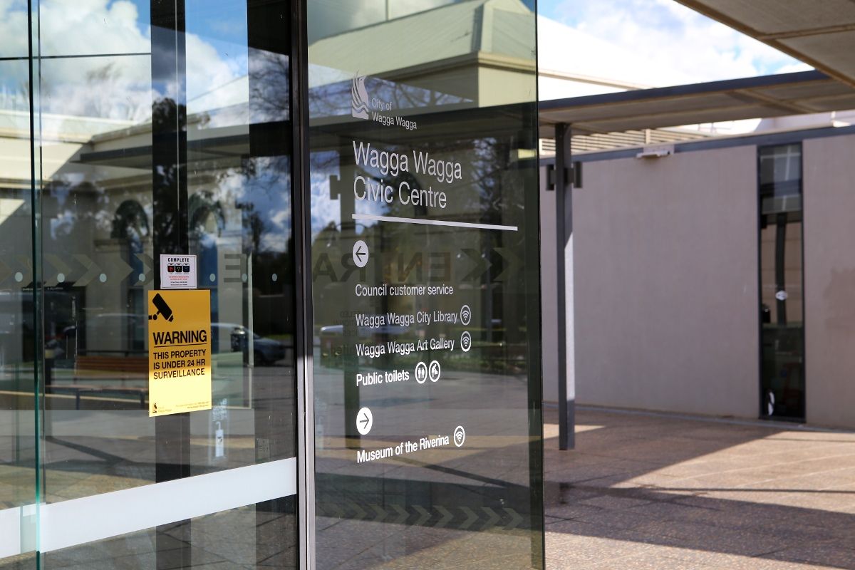 Sign on glass door warning about surveillance