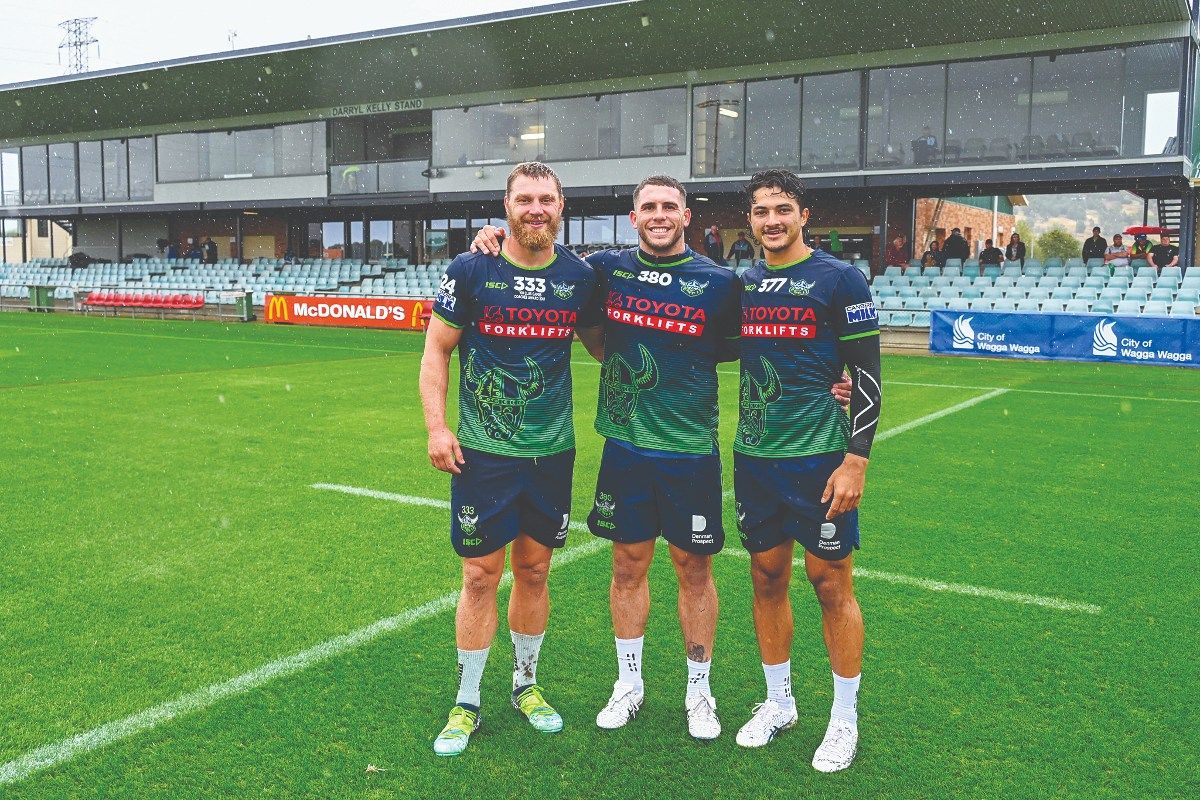 Three Raiders players standing in front of grandstand at McDonalds Park