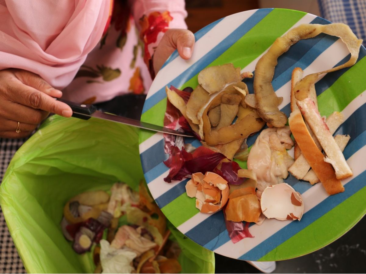 Person putting food scraps in a FOGO bin