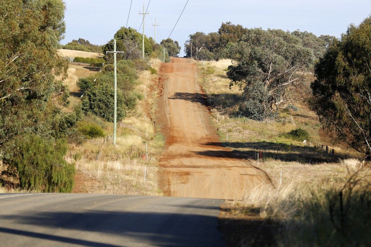 Dirt road with sealed road in foreground - Dunns Road