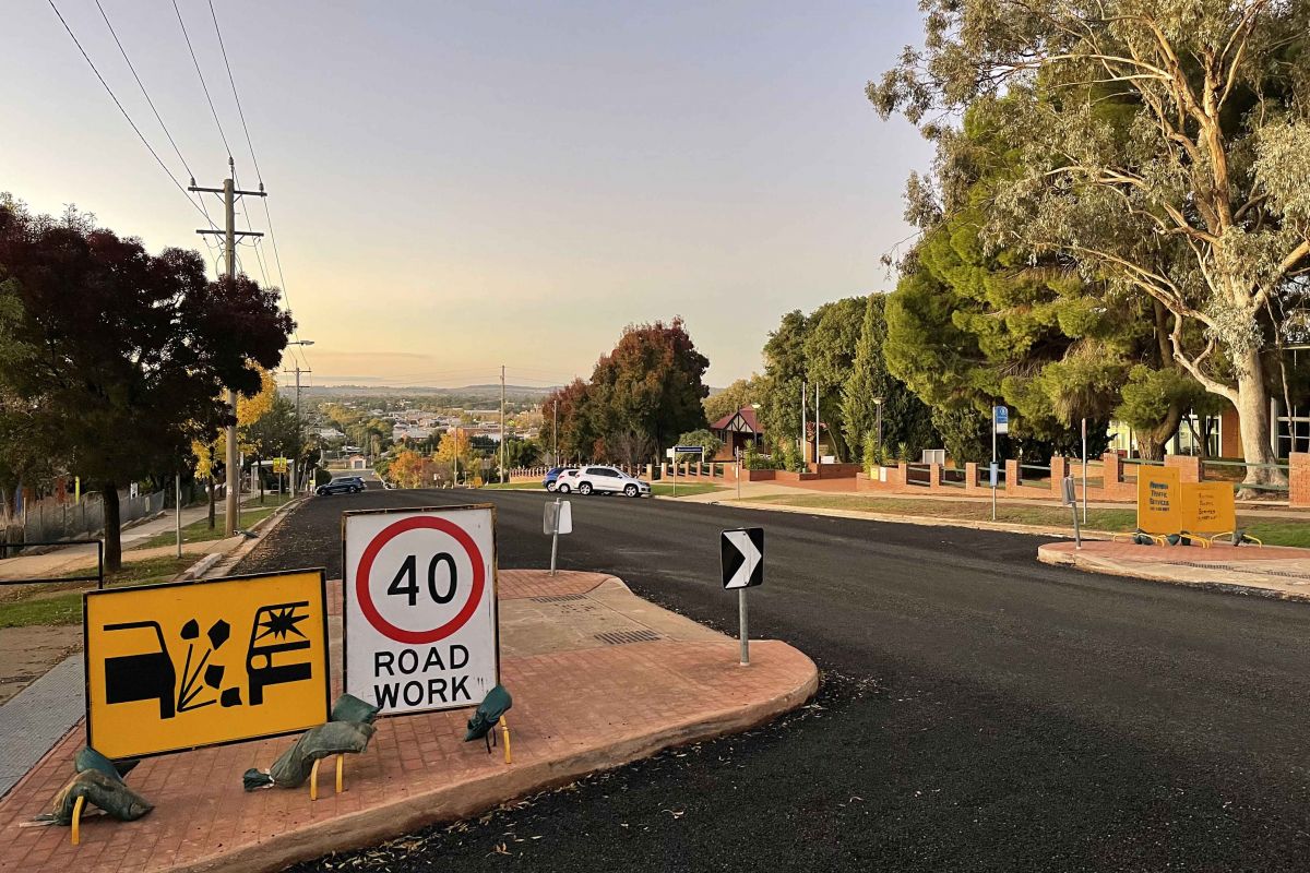 Freshly sealed road with 40kph sign in foreground on pedestrian refuge