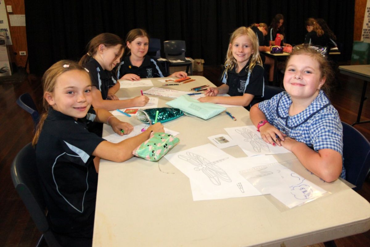 A group of students sitting around a table, colouring in