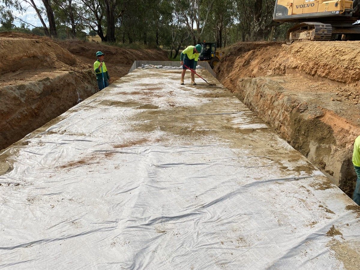 Two men working on an enormous concrete box culvert