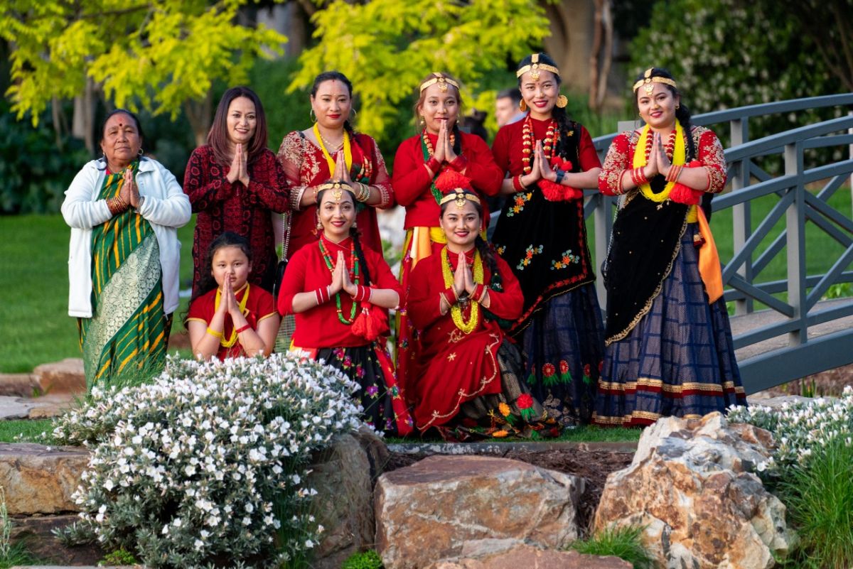 Riverina Nepalese Community Dancers in traditional dress line up for a photo in the Botanic Gardens