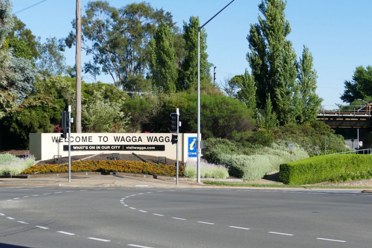 Major traffic intersection in foreground with large Welcome to Wagga Wagga sign in the background