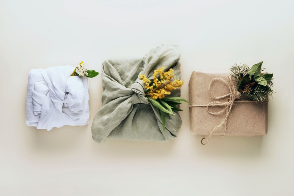 Three presents wrapped in recycled cloth and paper.