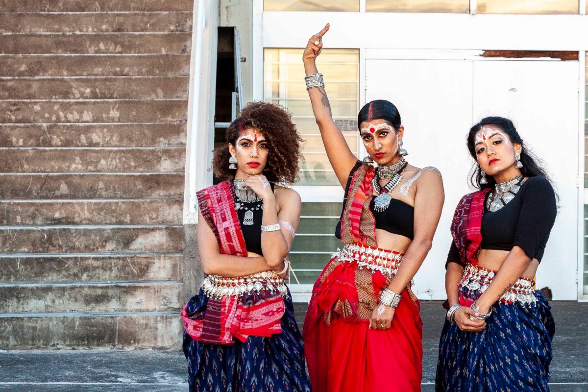 Three women in traditional India cultural dress in a dance formation