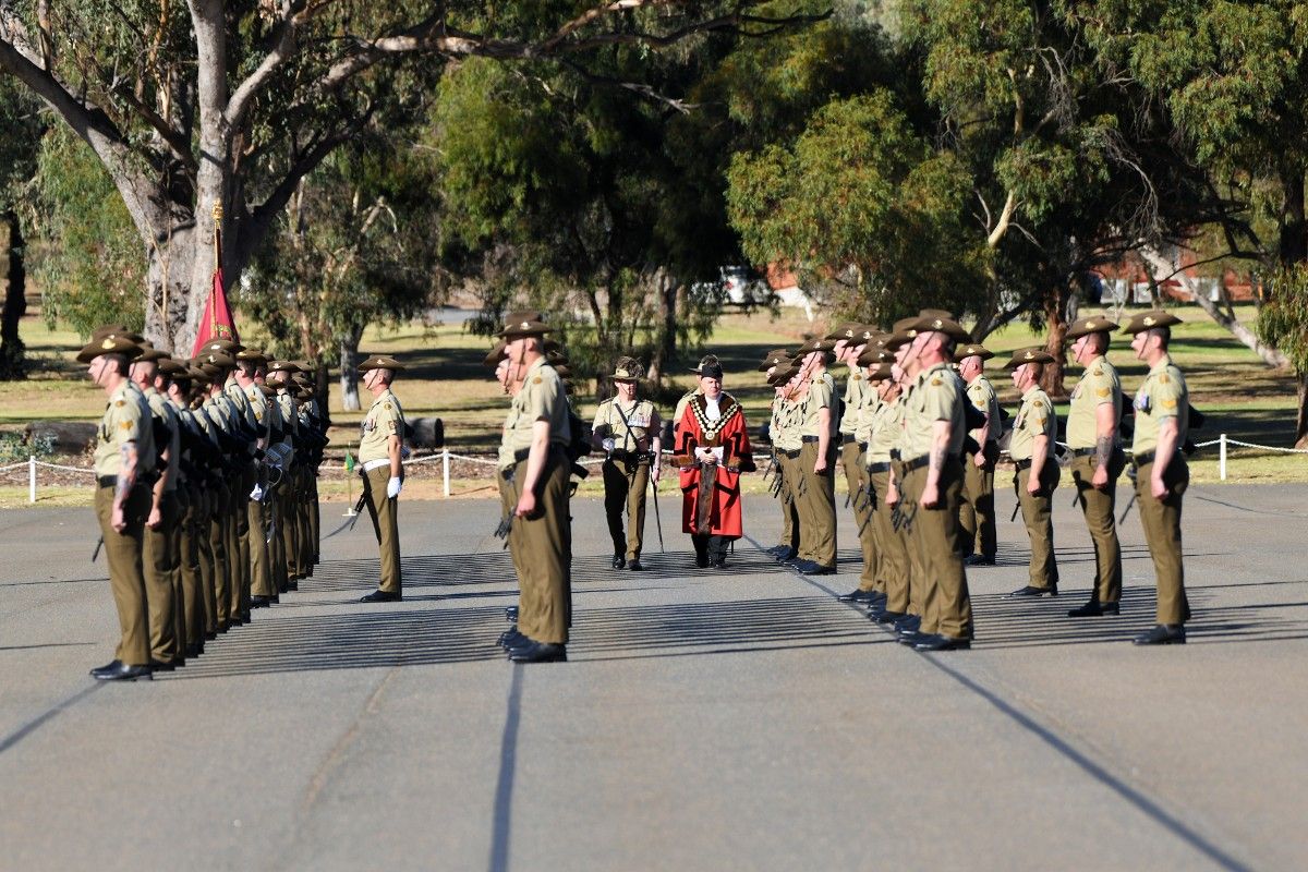 Soldiers on parade being inspected by man in mayoral robes