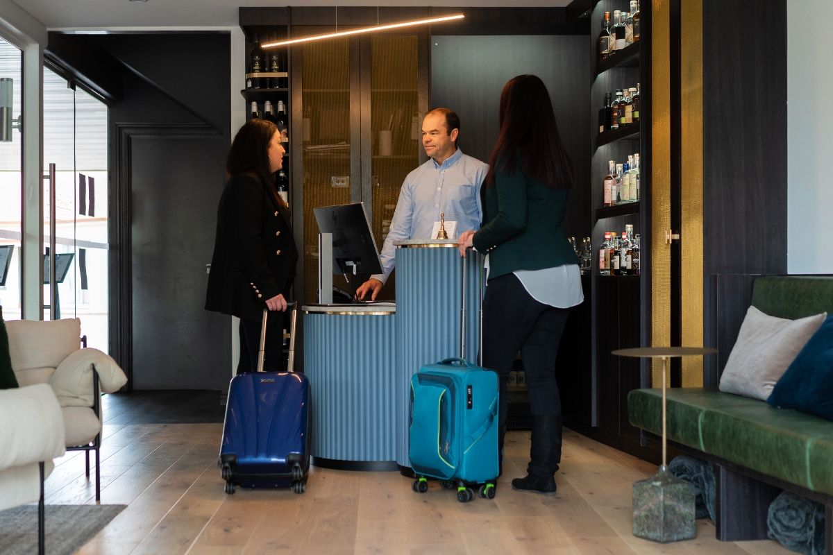 Two women and man standing in hotel reception