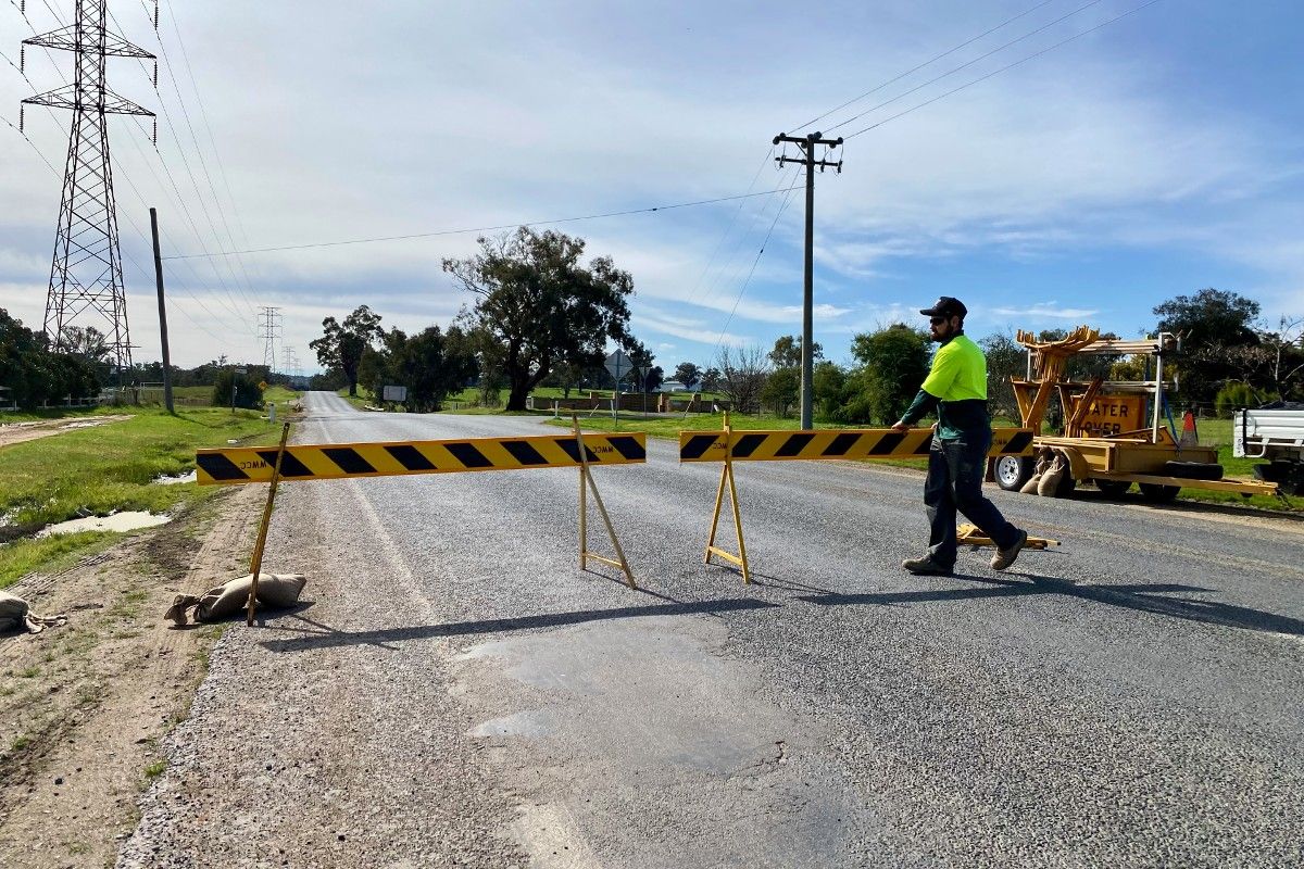 Council worker in hi-vis vest moving road barricade