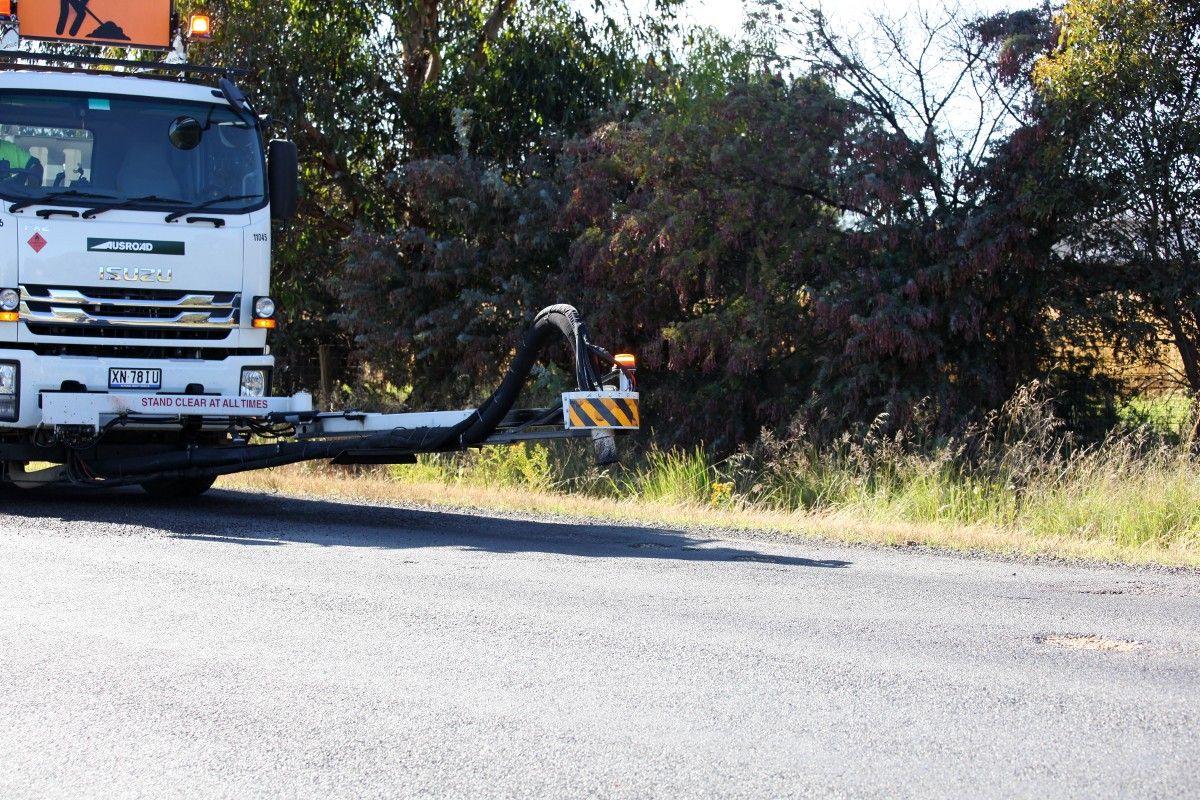 Jet patcher vehicle filling potholes on rural road