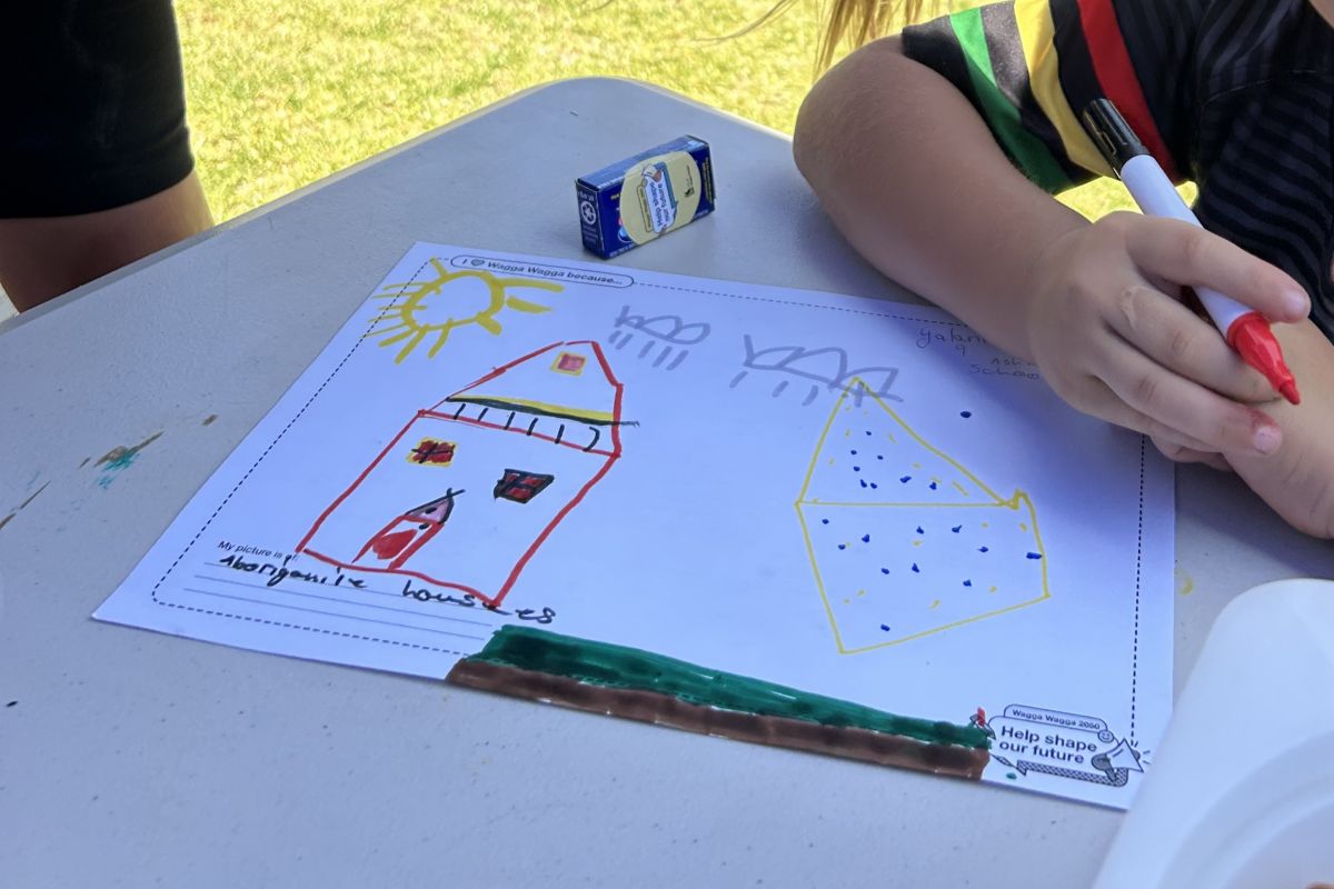 A close-up of a child's drawing of a house and landscape. 