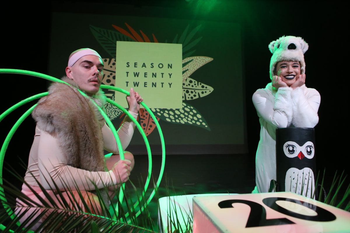 Male and female actors in costume on stage