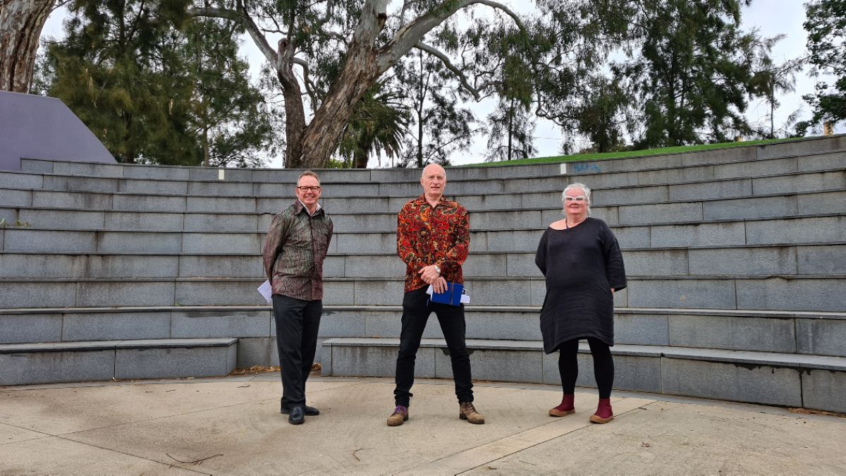 Two men and a woman standing in the bowl of a small amphitheatre