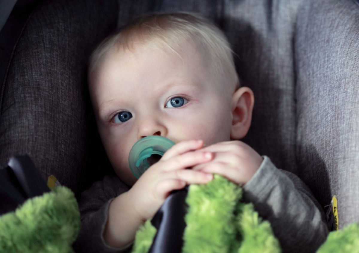 baby in child safety seat in vehicle